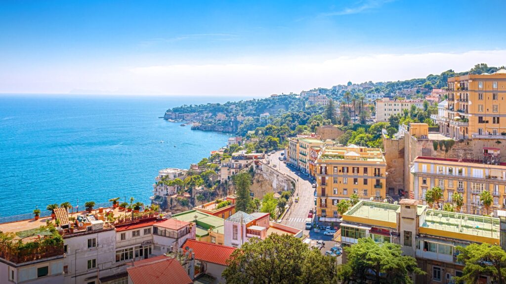 Motorcycle group riding through the picturesque Amalfi Coast, showcasing the stunning sea views and vibrant local atmosphere.