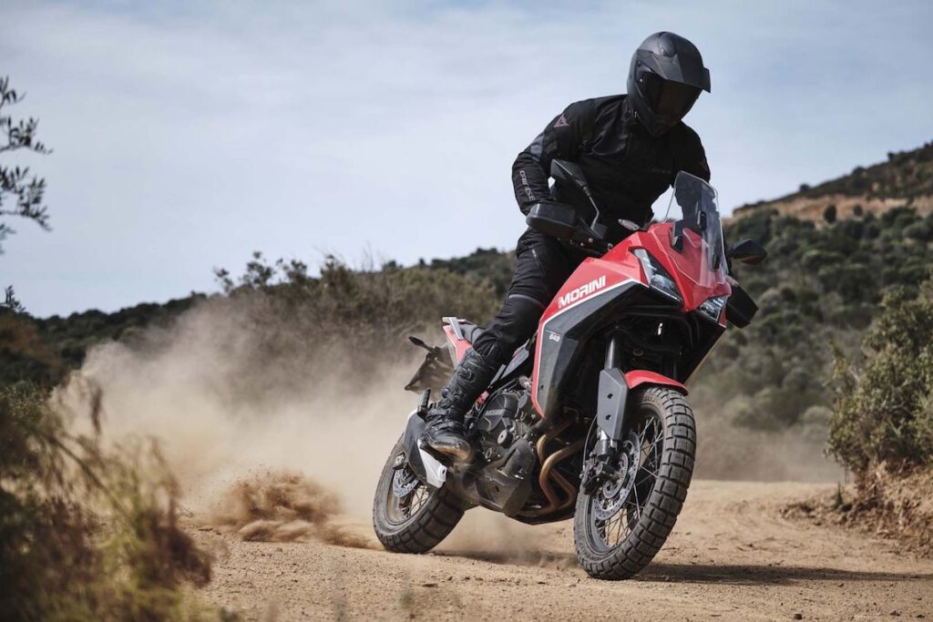 Motorcyclists conquering rugged off-road trails through Italy’s challenging terrains, kicking up dust in a thrilling adventure.