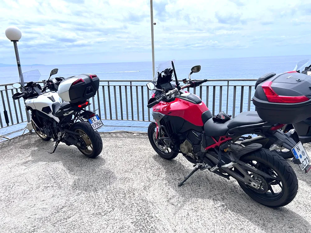 Italy Moto Tours Parked motorcycles with top cases overlooking the Amalfi Coast sea view during a break on a scenic Italy Moto Tours ride