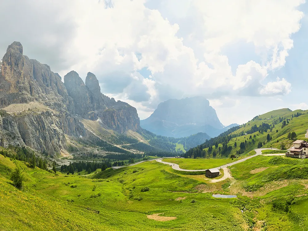Dolomite plateau, towering cliffs and ribbon road at Gardena Pass