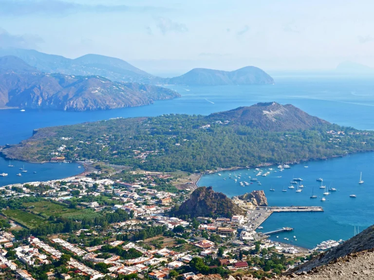 Italy Moto Tours Wide view of the Aeolian Islands with harbors, boats and volcanic hills in the Tyrrhenian Sea, Sicily, Italy.