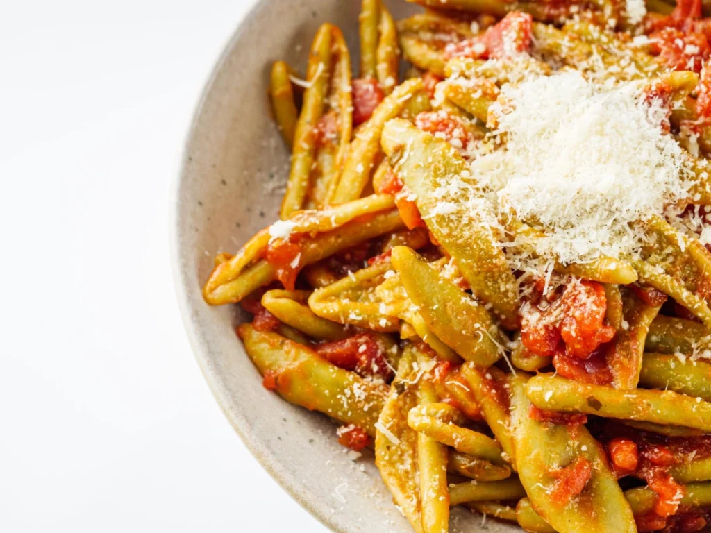 Italy Moto Tours Twisted strozzapreti pasta tossed in rich tomato sauce and topped with grated pecorino cheese.