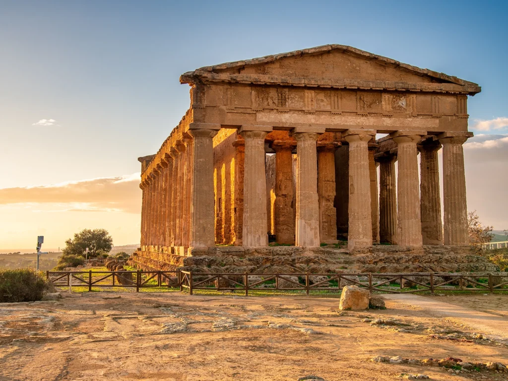 Italy Moto Tours Temple of Concordia glowing at sunset in the Valley of the Temples, Agrigento, Sicily, Italy.