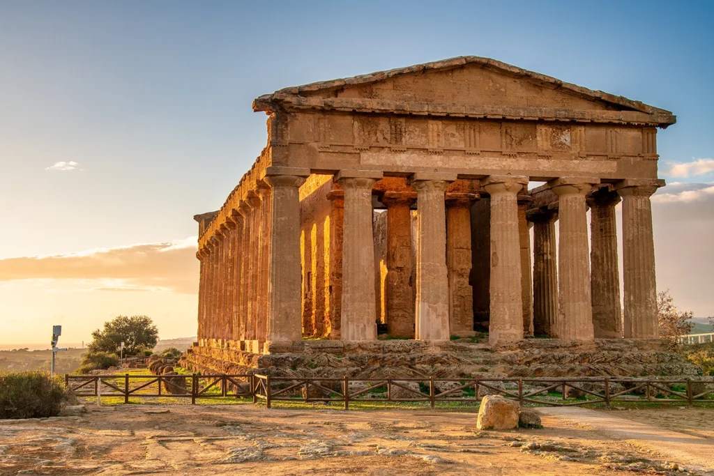 Italy Moto Tours Temple of Concordia glowing at sunset in the Valley of the Temples, Agrigento, Sicily, Italy.