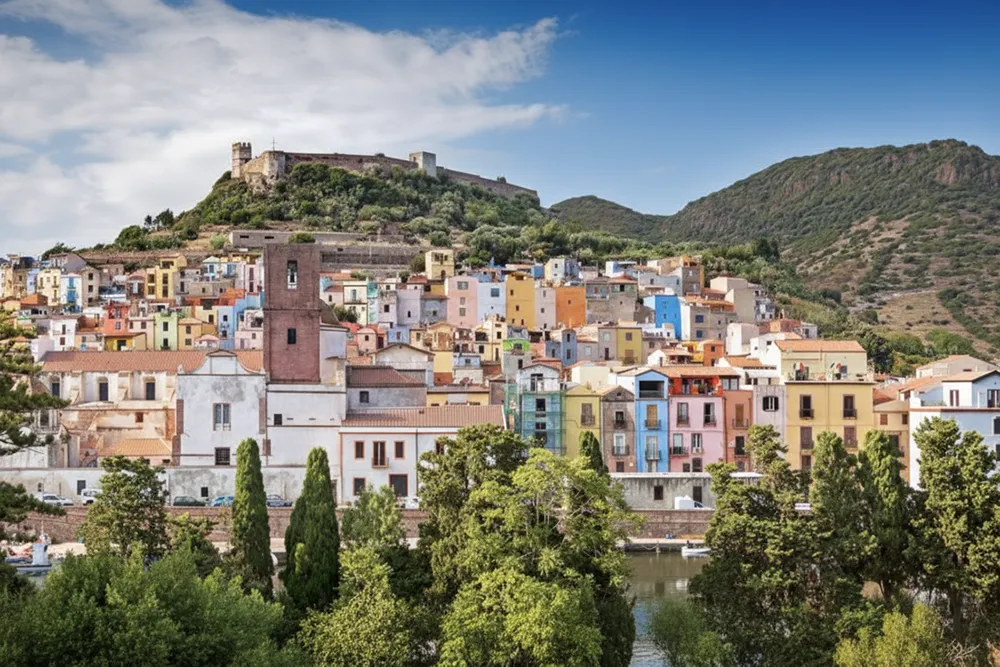 Italy Moto Tours Panorama of the colorful riverside town of Bosa in the Oristano area of Sardinia, crowned by Malaspina