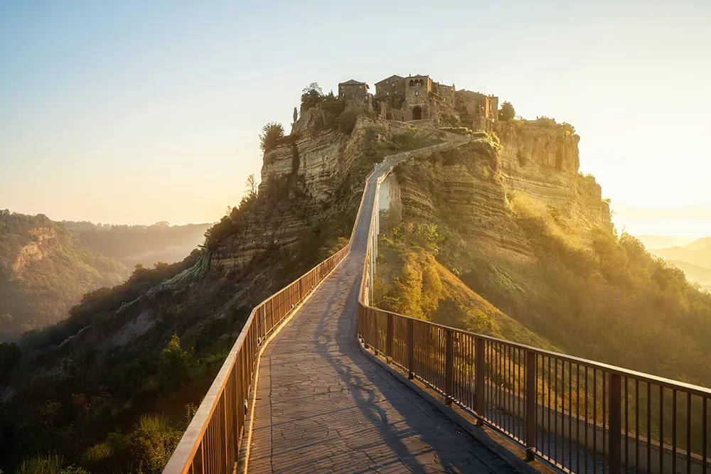 Italy Moto Tours Hilltop Civita di Bagnoregio in Tuscia, Lazio, Italy—medieval village reached by a dramatic footbridge.