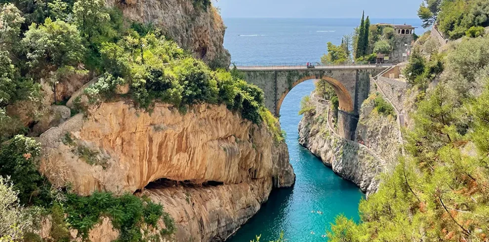 Stone arch bridge over the turquoise Fiordo di Furore on the Amalfi Coast, Italy