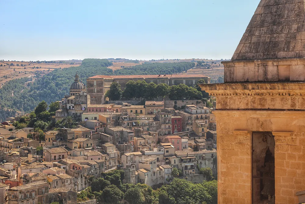 Italy Moto Tours Hilltop view of Ragusa Ibla with the dome of San Giorgio and layers of Baroque stone buildings.