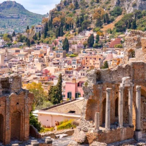 Ruins of the Greek–Roman theatre in Taormina with the colorful hillside town behind.