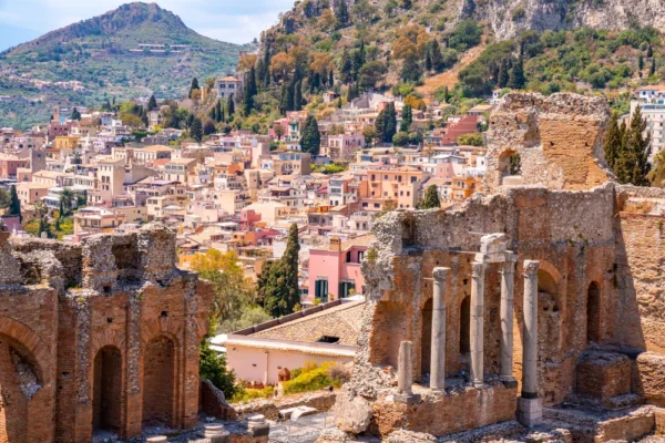 Ruins of the Greek–Roman theatre in Taormina with the colorful hillside town behind.
