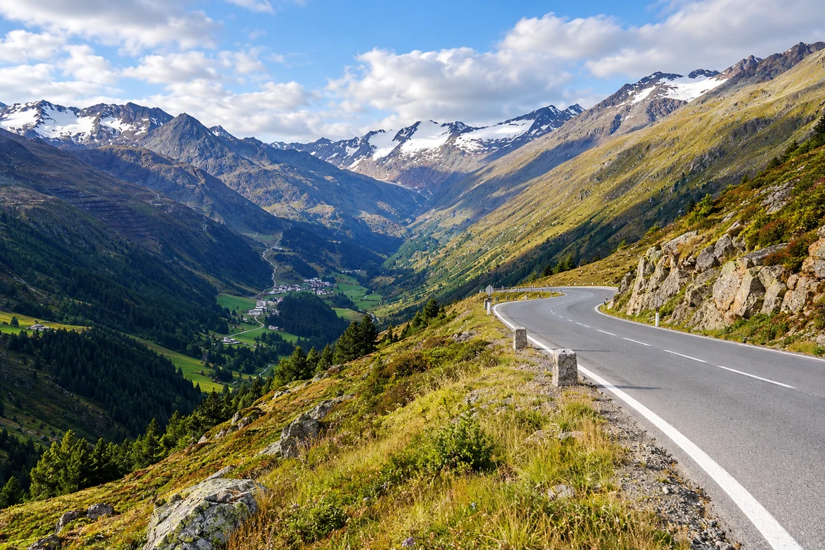 A curving alpine road above a broad mountain valley near Timmelsjoch.