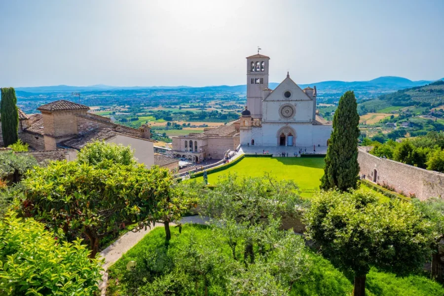 View of the Basilica of Saint Francis with gardens and the Umbrian valley in Assisi, Italy