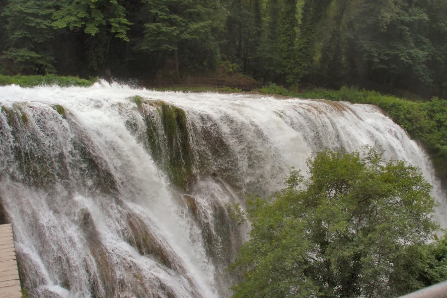 The cascades of the Marmore Waterfalls amid green hills in Umbria.